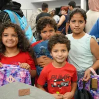 All smiles as students receive their new backpacks and get ready to head back to school. 